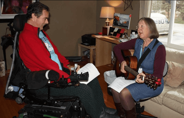 Music therapist Becky Pansch of Fairview Hospice in Minneapolis and client Kevin Pollari in his living room | Credit: Marie Gentile, Fairview Health Services